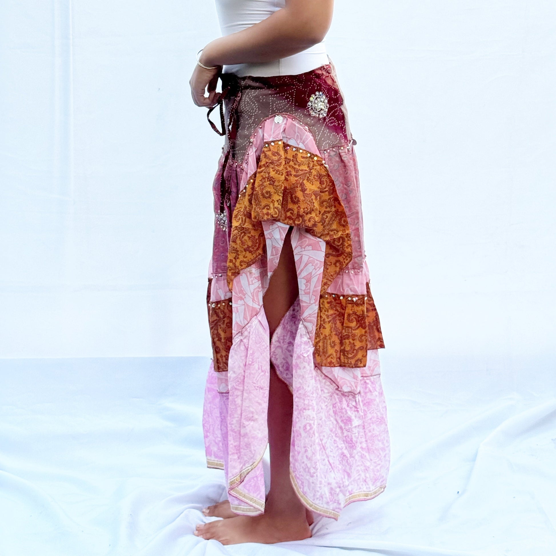 A patchwork skirt made from vintage saris, featuring soft pink, brown, and gold tones with intricate patterns. It includes an adjustable drawstring for a comfortable fit.