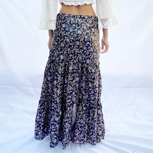A drawstring skirt made from vintage sari fabric, featuring intricate patterns in shades of black, beige, and blue with floral designs. The adjustable fit adds elegance and comfort.